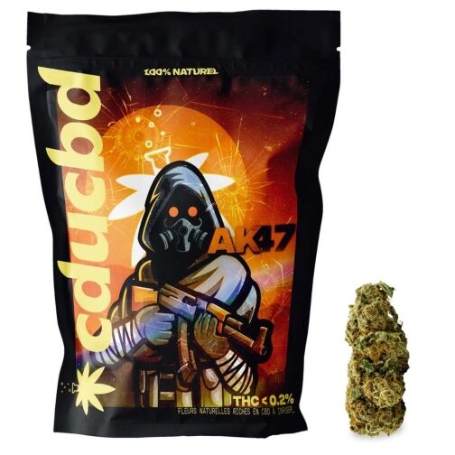 Un sachet noir, décoré d’un personnage masqué « AK47 », à côté d’une fleur de chanvre verte.