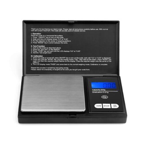 Balance de précision électronique noire avec écran LCD rétroéclairé bleu, plateau en acier inoxydable et couvercle contenant les instructions d’utilisation.