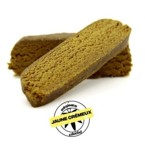 Deux blocs de résine brun-jaune, allongés, dont la coupe révèle une texture moelleuse.