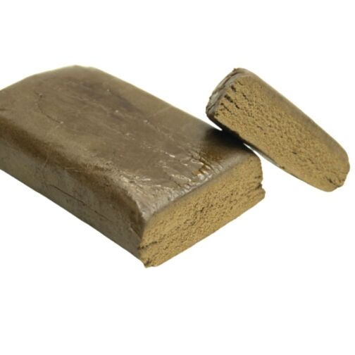 Bloc de résine marron clair avec une texture dense et une surface légèrement brillante, un morceau coupé en évidence.