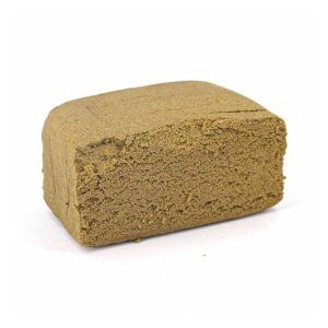 Bloc de résine CBD couleur beige clair avec texture fine et compacte, légèrement poudreuse sur la surface.